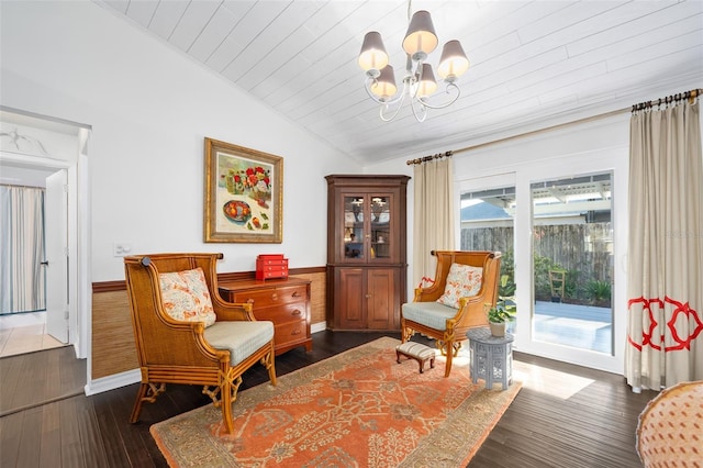 sitting room featuring a wainscoted wall, lofted ceiling, dark wood-type flooring, wooden ceiling, and a notable chandelier