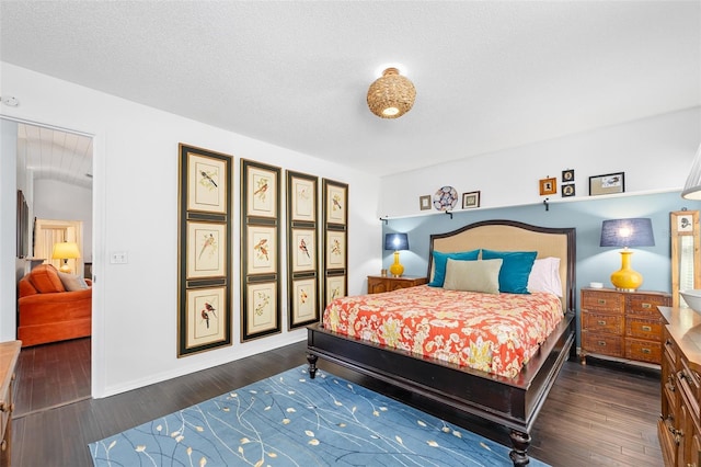 bedroom with baseboards, a textured ceiling, and dark wood finished floors