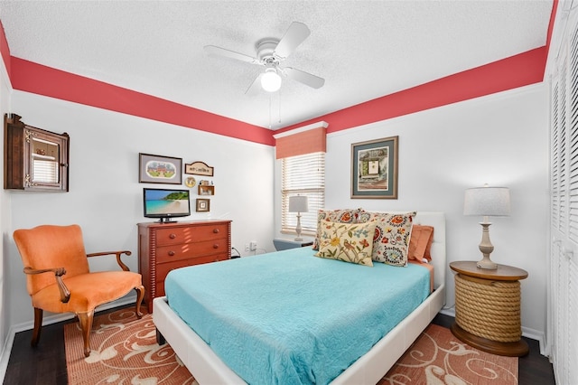 bedroom featuring a ceiling fan, wood finished floors, baseboards, and a textured ceiling