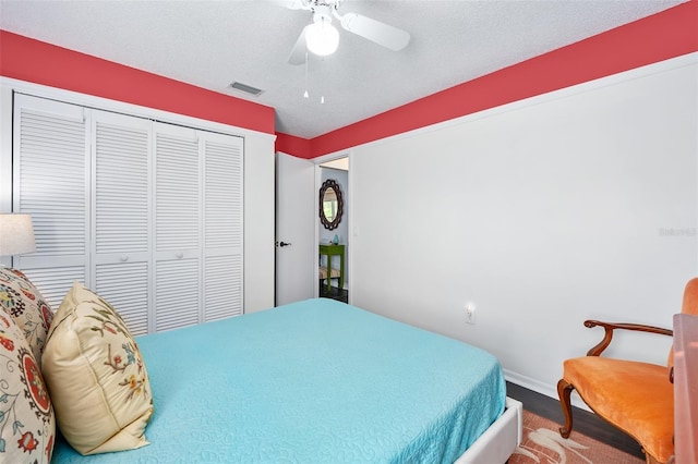 bedroom with visible vents, baseboards, a closet, a textured ceiling, and a ceiling fan