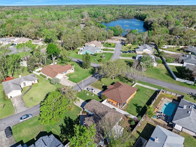 aerial view featuring a view of trees, a water view, and a residential view