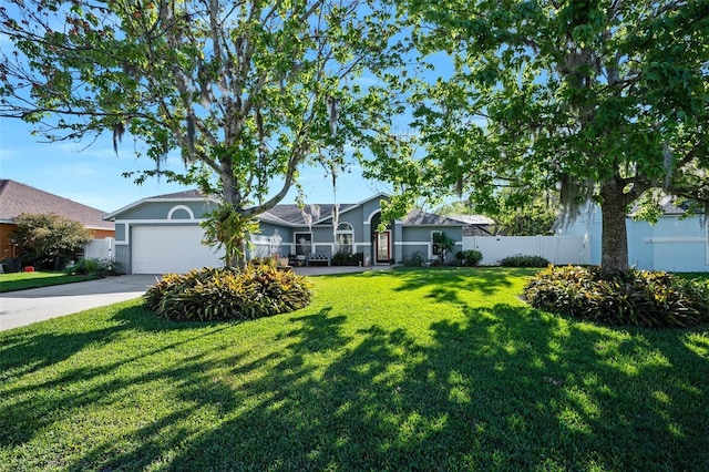 ranch-style home featuring a front lawn, an attached garage, driveway, and fence