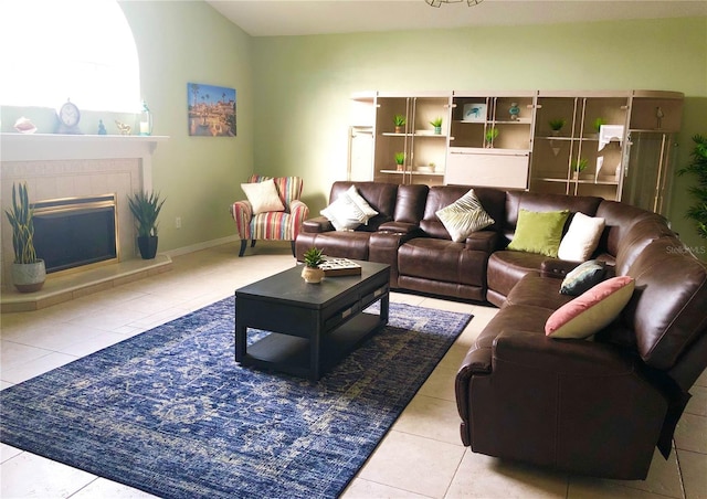 tiled living area featuring a fireplace and baseboards