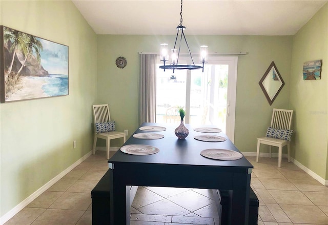 dining area featuring light tile patterned floors, baseboards, and a chandelier