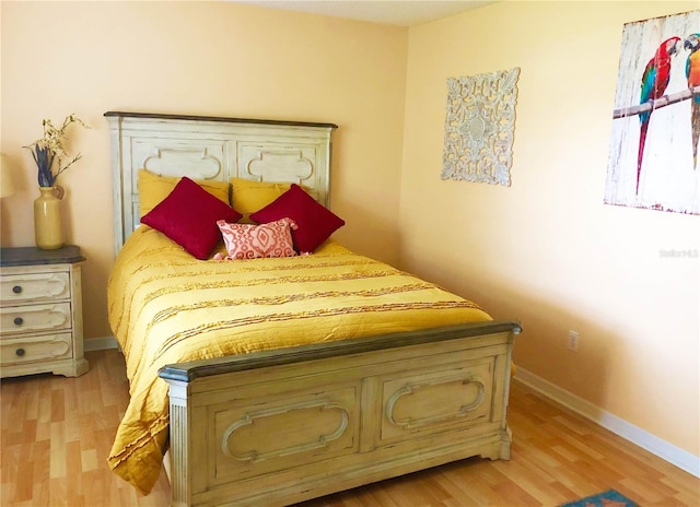 bedroom with baseboards and light wood finished floors