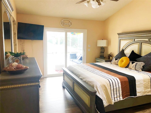 bedroom featuring a ceiling fan, access to exterior, wood finished floors, and vaulted ceiling