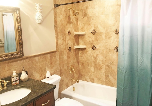 bathroom with vanity, tile walls, toilet, and shower / bath combo with shower curtain