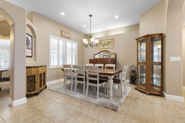 dining space with baseboards, recessed lighting, arched walkways, an inviting chandelier, and light tile patterned flooring