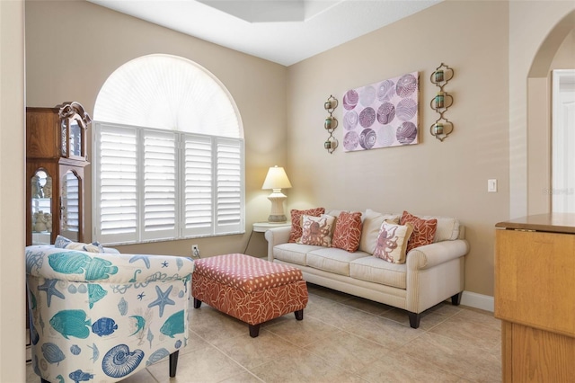 living area with arched walkways and light tile patterned floors