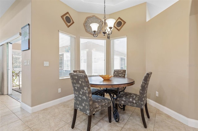 dining area with light tile patterned floors, baseboards, and a notable chandelier