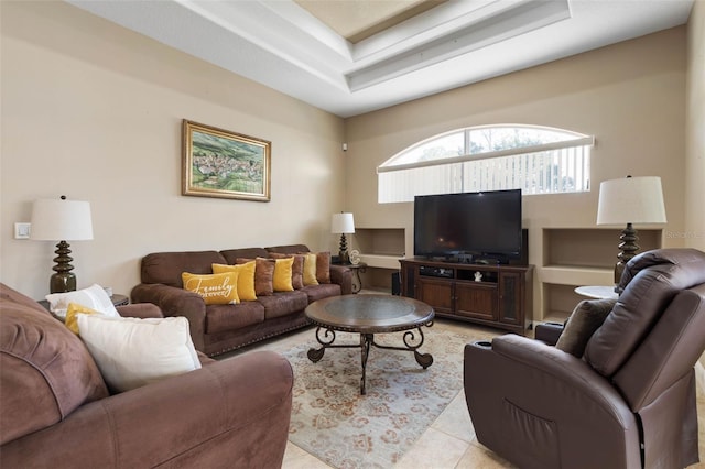 living area featuring a tray ceiling and light tile patterned floors