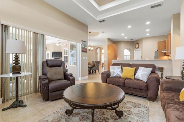 living area with arched walkways, visible vents, recessed lighting, and light tile patterned floors