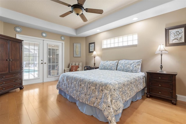 bedroom with access to exterior, light wood-style flooring, french doors, and multiple windows