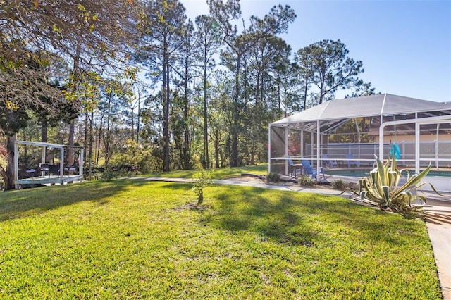 view of yard with glass enclosure and an outdoor pool