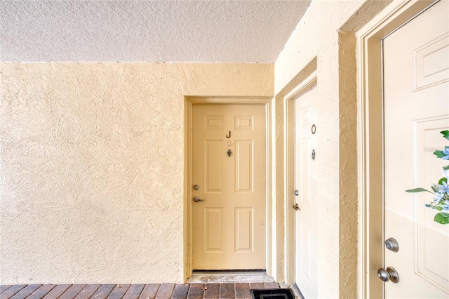 doorway to property featuring stucco siding