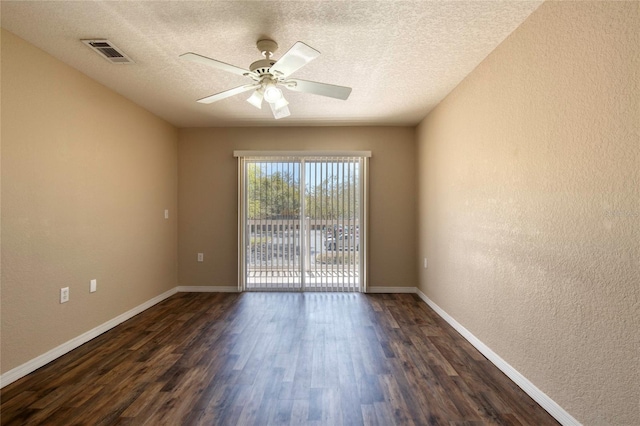 spare room featuring visible vents, baseboards, dark wood-type flooring, and a ceiling fan