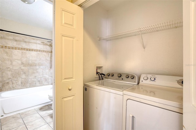 laundry area with laundry area, light tile patterned flooring, and washer and clothes dryer