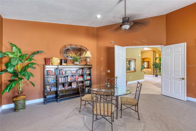 dining room with baseboards, arched walkways, a ceiling fan, and carpet flooring