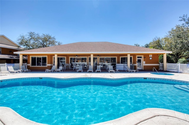 pool with a community hot tub, a ceiling fan, a patio, and fence