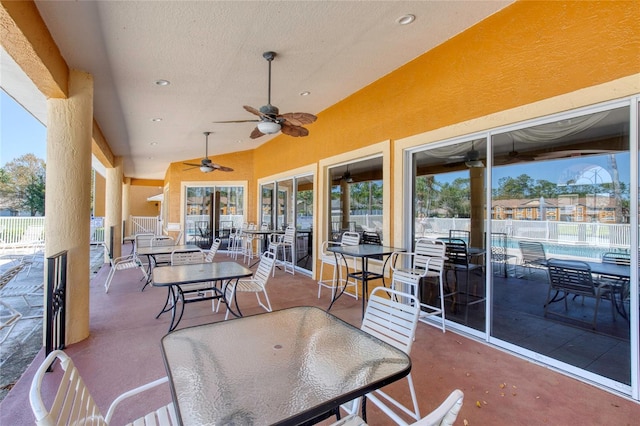 view of patio with outdoor dining space, fence, and a ceiling fan