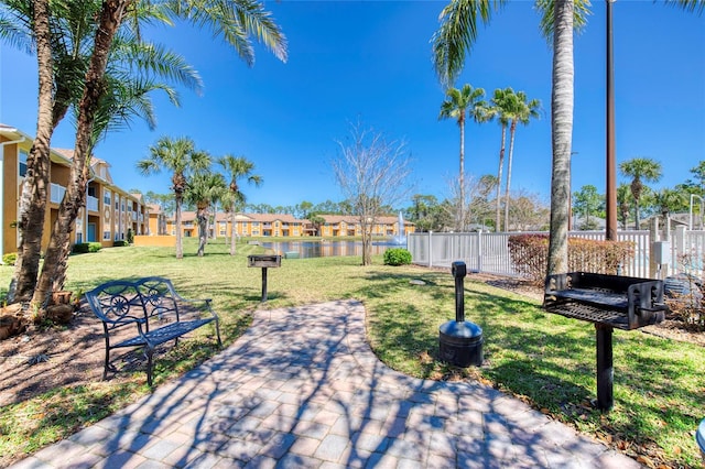 view of community featuring a residential view, a yard, and fence