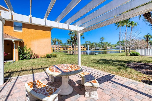 view of patio / terrace with a water view and fence