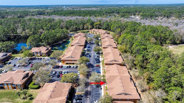 bird's eye view featuring a wooded view and a water view