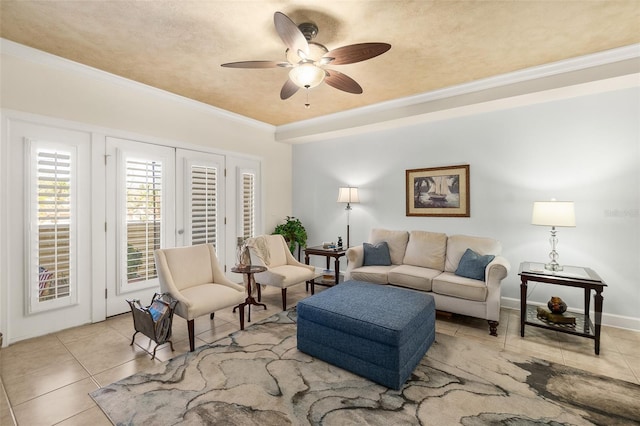 living area with tile patterned floors, baseboards, a ceiling fan, and ornamental molding