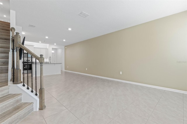 interior space featuring light tile patterned floors, baseboards, visible vents, recessed lighting, and stairs