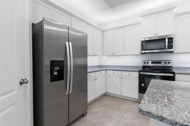 kitchen featuring light tile patterned floors, white cabinets, stainless steel appliances, and light stone countertops