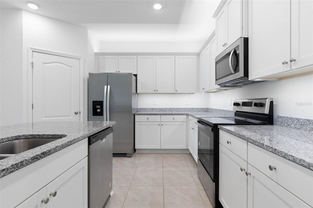 kitchen featuring light tile patterned floors, light stone countertops, recessed lighting, white cabinets, and appliances with stainless steel finishes