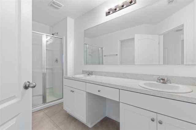 full bathroom with a sink, a stall shower, and tile patterned flooring