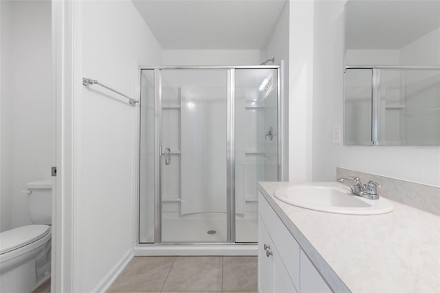 bathroom with vanity, a shower stall, toilet, and tile patterned floors