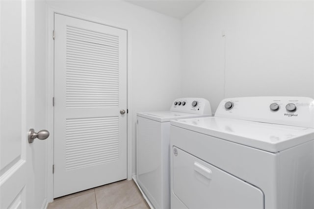 laundry room featuring laundry area, light tile patterned floors, and separate washer and dryer