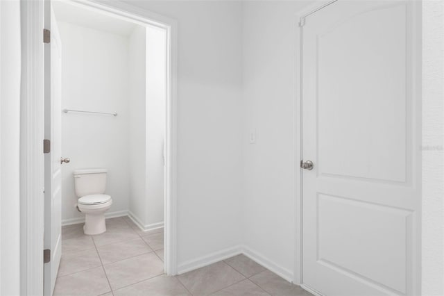 bathroom with tile patterned floors, toilet, and baseboards