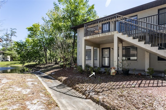 view of home's exterior with stucco siding and a water view