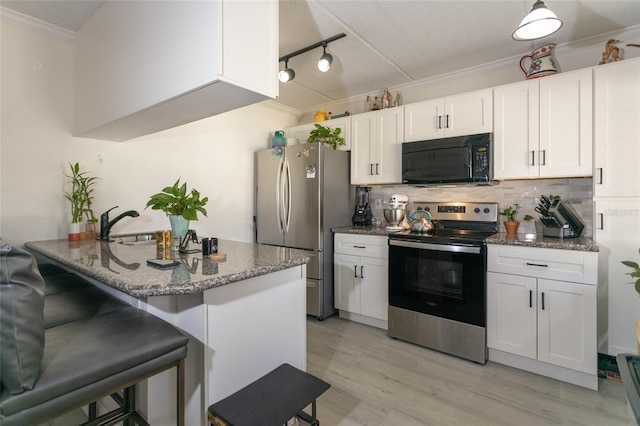 kitchen with tasteful backsplash, crown molding, a breakfast bar, stainless steel appliances, and white cabinetry