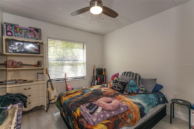 bedroom with ceiling fan, a textured ceiling, and light wood-style flooring