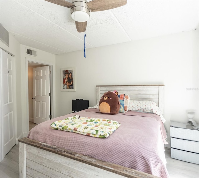 bedroom featuring visible vents, wood finished floors, and a ceiling fan