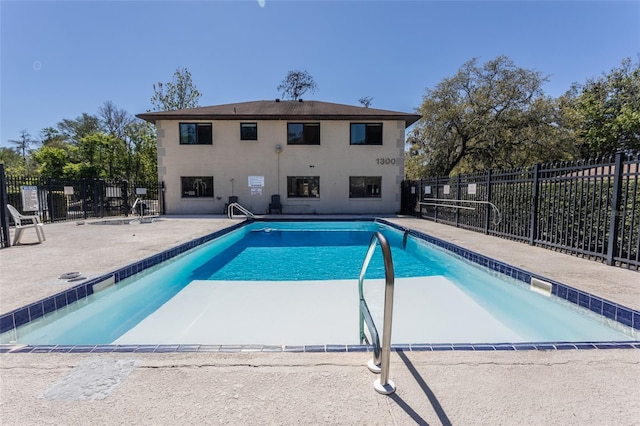 community pool with a patio and fence