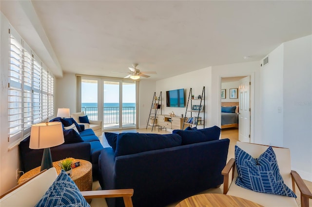 living area with visible vents and ceiling fan