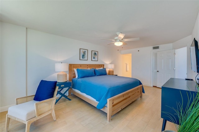 bedroom with visible vents, baseboards, light wood-type flooring, and a ceiling fan