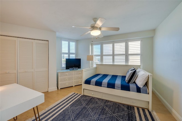 bedroom featuring a ceiling fan, wood finished floors, a closet, and baseboards