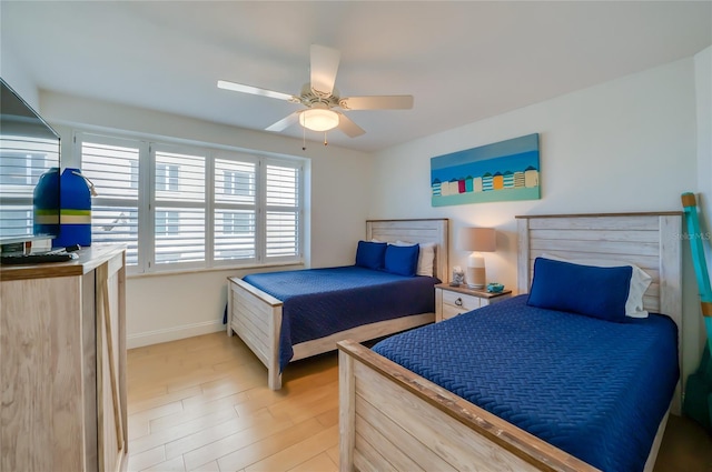 bedroom with baseboards, light wood-style floors, and ceiling fan