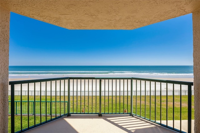 balcony with a beach view and a water view