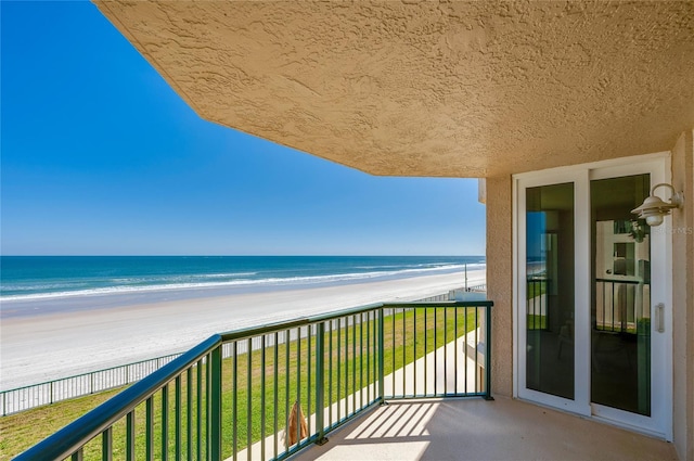 balcony featuring a beach view and a water view