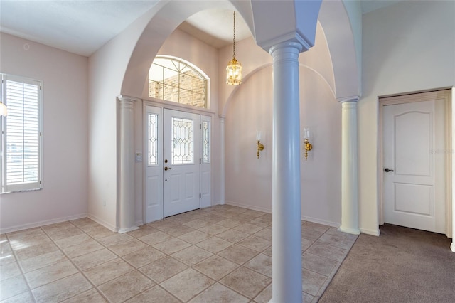 entrance foyer with light tile patterned flooring, arched walkways, baseboards, and ornate columns