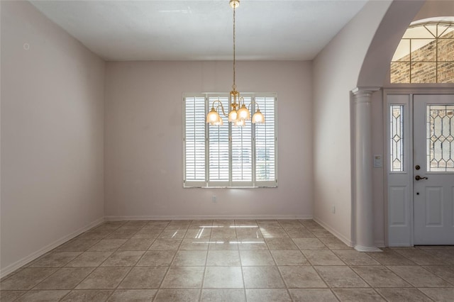 entryway with a chandelier, light tile patterned floors, baseboards, and decorative columns