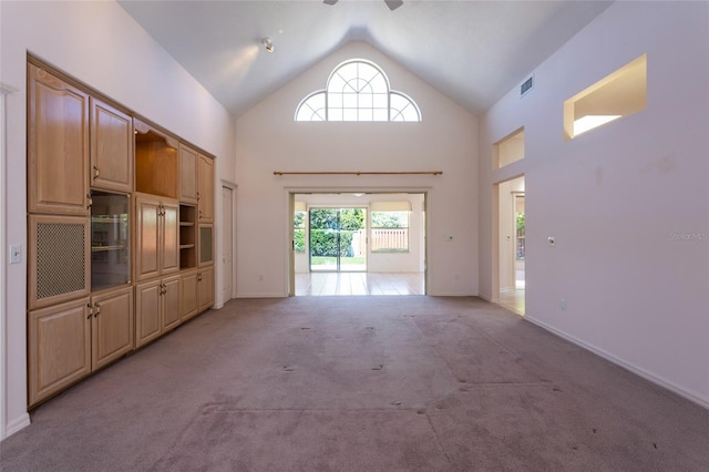 interior space with visible vents, baseboards, light carpet, high vaulted ceiling, and a ceiling fan