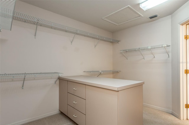 spacious closet with visible vents, light colored carpet, and attic access